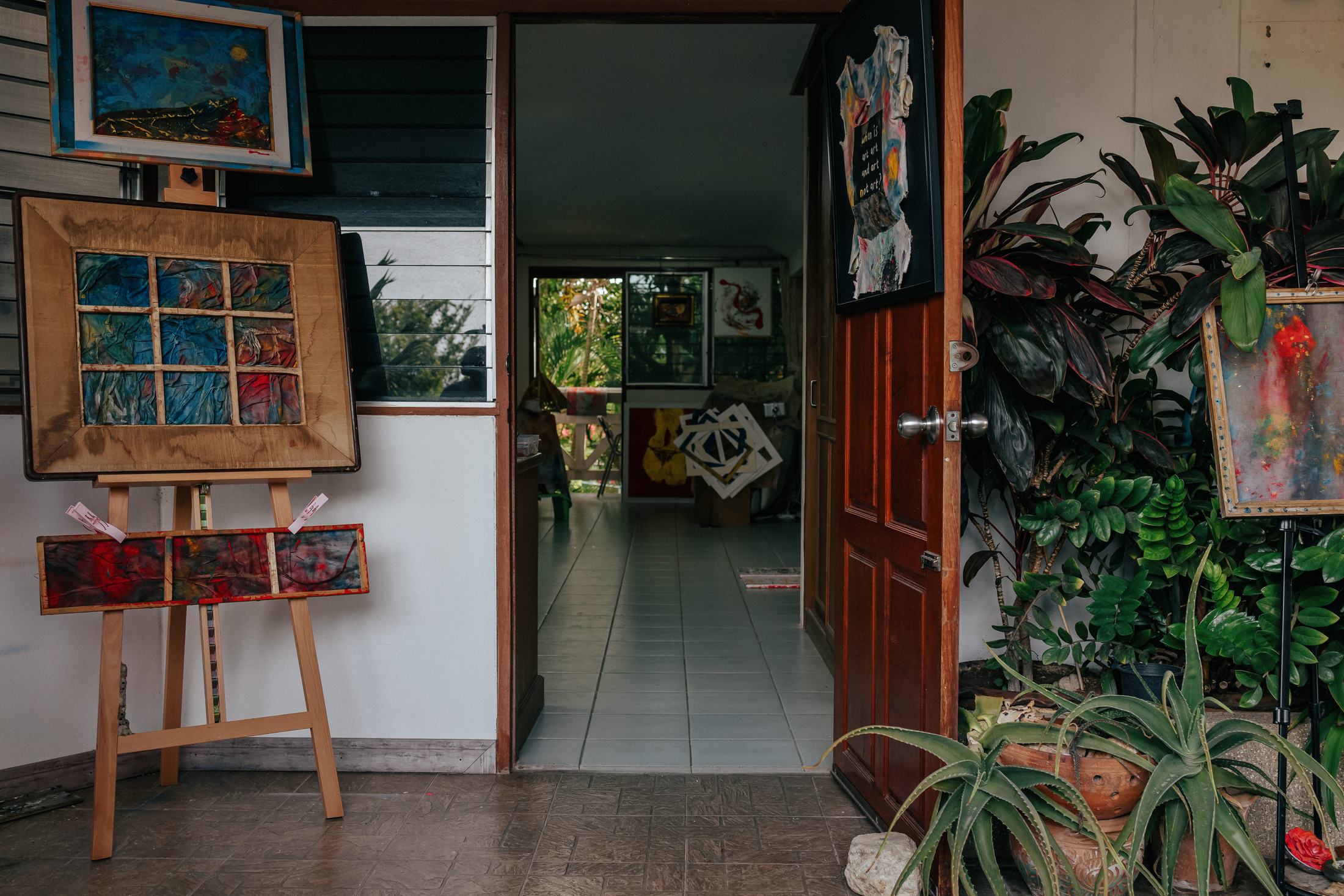The doorway of Nana Bors's studio in Thailand, works on easels and against the walls